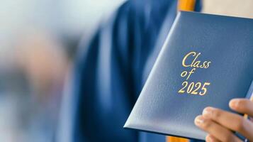 Hands of a graduate display diploma celebrating Class of 2025, marking a significant educational milestone photo