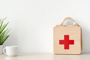A wooden toy first aid kit sits on a children's table next to a toy tea cup in warm sunlight photo
