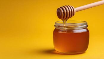 Golden honey dripping from wooden dipper into clear jar kitchen setting product photography bright background photo