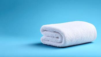 Neatly folded white towel on smooth pastel background product photography indoor minimalist conceptual photo