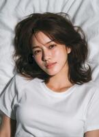 Captivating moment asian girl lying on white fabric portrait photography indoor topdown view photo