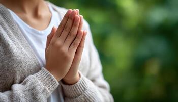 Hands in prayer pose soft natural light reflective mood outdoor setting serene environment photo