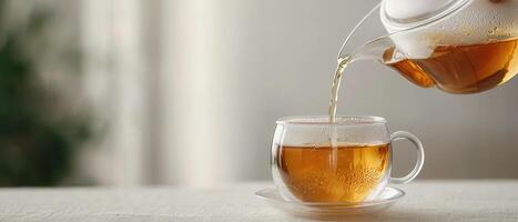 Hand pouring tea into glass cup on natural linen table cozy indoor environment high-quality photography photo