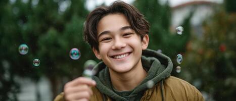 Joyful asian boy playing with soap bubbles outdoors smiling natural environment close-up photo