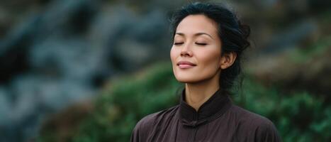 Asian woman meditating in nature serene expression outdoor setting peaceful environment photo