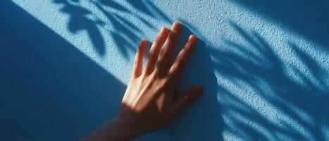 Artistic shadow of hand on pastel wall sunlit environment minimalist photo