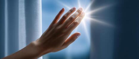 Reaching for sunlight a female hand touching white curtain bright indoor inspirational view photo