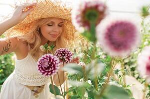 In ,straw hat, with plants. Beautiful woman is in the greenhouse photo