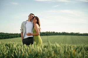 Standing and, posing... Lovely couple are on the agricultural field together photo