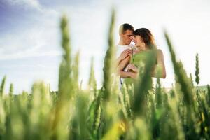 In green dress and ,white, clothes. Lovely couple are on the agricultural field together photo