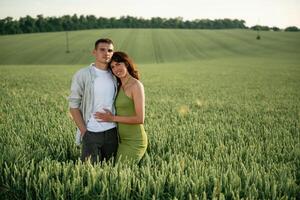 Standing and posing.. Lovely couple are on the agricultural field together photo