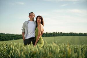 Standing and, posing. Lovely couple are on the agricultural field together photo
