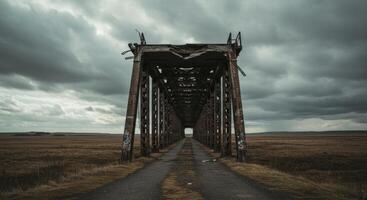 Dilapidated steel bridge on a desolate plain under an ominous sky, showcasing industrial decay photo