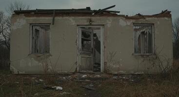 Desolate house embodies decay, featuring broken windows and crumbling walls photo