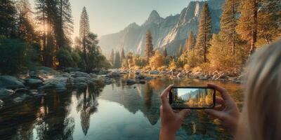 Capturing a serene river view in the mountains during golden hour with a smartphone in hand photo