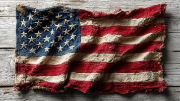 Worn and weathered US flag resting on a rustic wooden surface in a warm, inviting light setting photo