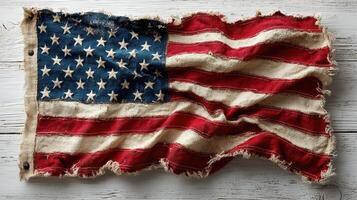 Worn flag displayed on rustic wooden surface highlighting patriotism and history in a timeless setting photo