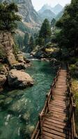 Beautiful wooden bridge crossing a serene river surrounded by mountains in a peaceful natural landscape during daytime photo