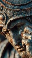 Close-up view of an ancient statue with intricate details, showcasing emotions under warm sunlight in a historic park photo