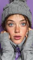 Young woman poses in gray sweater and hat against a vibrant purple background during a winter-themed photoshoot focusing on expressions photo