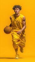 Young basketball player in bright yellow outfit runs with ball against a vibrant yellow background during a dynamic practice session photo