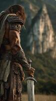Strong warrior ready for battle with sword in hand against majestic mountain backdrop at sunset photo