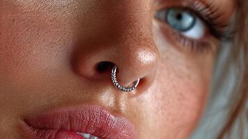 Close-up of a woman showcasing a silver nose ring amidst natural skin tones and detailed features in bright lighting photo
