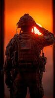 Soldier saluting the sunset in a military setting at dusk conveying respect and duty photo