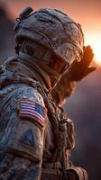Soldier salutes the setting sun amidst a rugged landscape during twilight hours photo