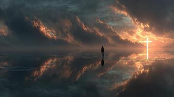 Solitary figure at sunset by the water reflecting clouds and a cross in the sky photo