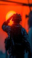Military personnel saluting against a vibrant sunset over the horizon in a display of respect photo