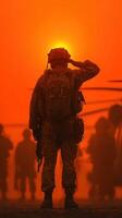 Soldier saluting against a dramatic sunset backdrop during a military operation in a desert landscape photo