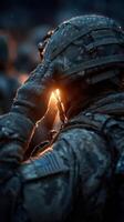 Soldier saluting during dawn with sunlight reflecting off military helmet in a wet environment photo