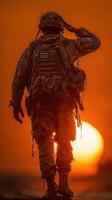 Soldier saluting at sunset on a military mission in a rugged environment photo