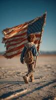 Young boy carrying worn American flag while walking across dusty landscape under clear blue sky photo
