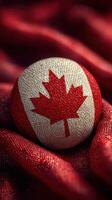 Canadian flag-inspired ball resting on textured red fabric in a cozy setting perfect for celebrations photo