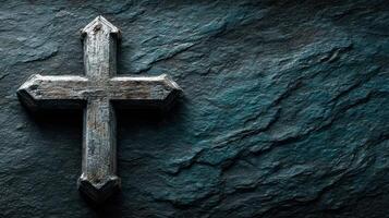 Wooden cross displayed on textured dark stone surface highlighting craftsmanship and religion photo