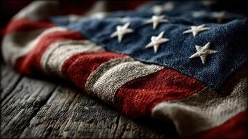 Weathered American flag draped on wooden surface, showcasing rich colors and texture during a cozy indoor moment photo