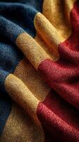 Textured fabric with bold colors showcasing deep blue, rich burgundy, and bright gold tones in soft folds photo