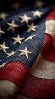 Close-up view of a worn American flag showcasing vibrant colors and detailed stitching against a dark background photo