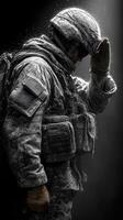 Soldier in camouflage uniform saluting with respect in a dramatic light setting photo