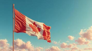 Canadian flag waving proudly against a bright blue sky with scattered clouds during a sunny day photo