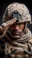 Soldier saluting in a dusty uniform with tactical gear during a military operation in a rugged environment photo