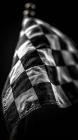 Black and white checkered flag waving proudly during a motorsport event in the afternoon sun photo