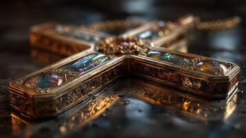 Golden ornate cross adorned with jewels rests on a reflective surface in a dimly lit environment photo