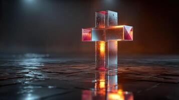 Crystal cross illuminated in a dark room with ambient lighting and reflections on the floor surface photo
