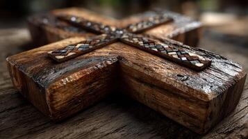 Carved wooden cross with ornate details displayed on rustic wooden surface in soft natural light photo