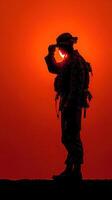 Sunset salute by a soldier in silhouette at a military training ground photo