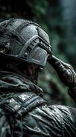 Military soldier in a wet environment adjusting helmet during a tactical mission in a forest setting at dusk photo