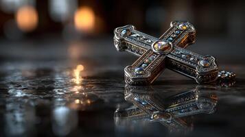 Intricate silver cross resting on a reflective surface with soft lights in the background during a quiet moment photo